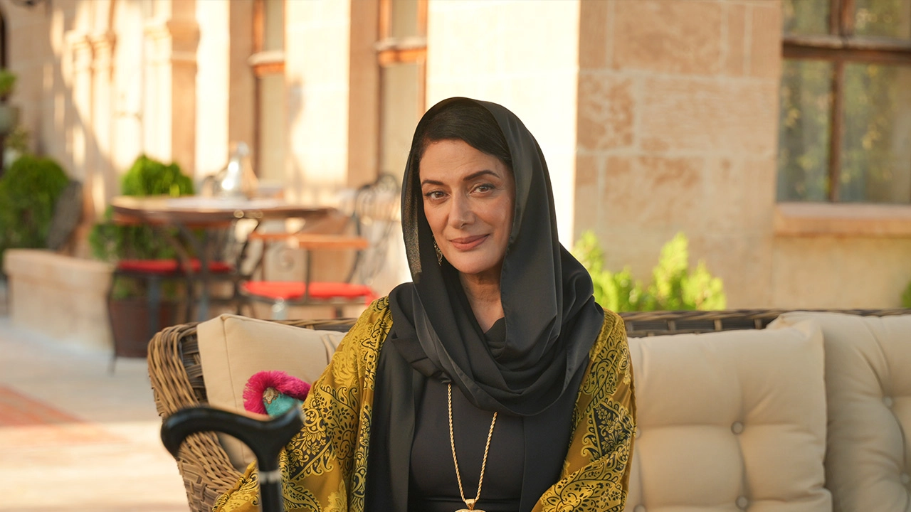Veda Yurtsever, Halef: Köklerin Çağrısı dizisinde güçlü ve sakin duruşuyla karakterini yansıtırken, açık havada otururken görülüyor. Veda Yurtsever, Halef: Köklerin Çağrısı dizisinde güçlü ve sakin duruşuyla karakterini yansıtırken, açık havada otururken görülüyor.